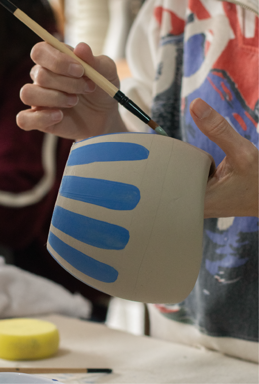 Bowl de cer&aacute;mica con borde azul y una flor azul pintada en el fondo, hecho en el taller